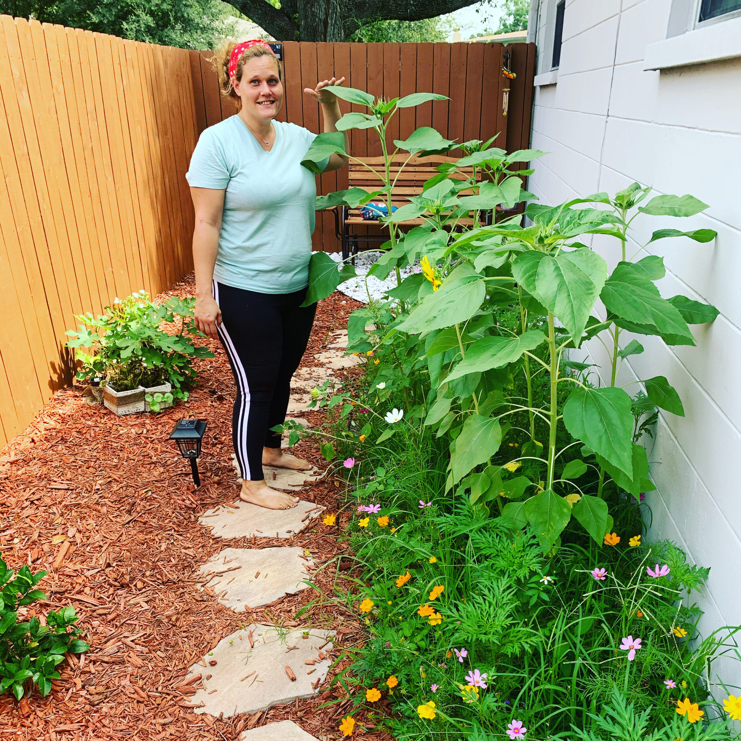 My wife stands in one of our pollinator gardens. Pollinators like butterflies and bees love it.